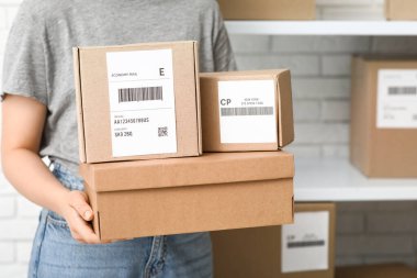 Posta deposunda paket kutuları olan kadın, yakın plan.