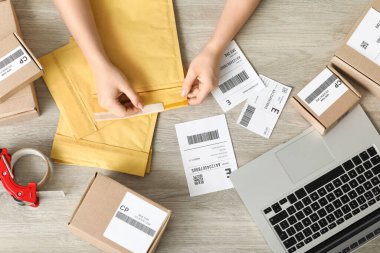 Masada paketler ve etiketlerle kadın posta işçisi, üst görünüm