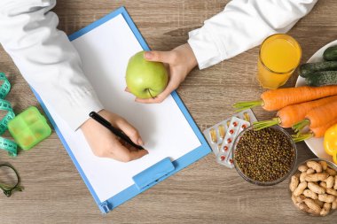 Genç bayan beslenme uzmanı, pano ve sağlıklı gıda diyet planı, üst görünüm.