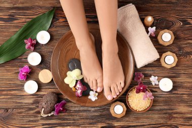 Ahşap arka planda spa tedavisi gören bir kadın.