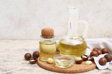 Mantar tepsisi, şişe, sürahi ve kase grunge masasında macadamia yağı, yakın plan.