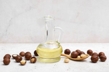 Işık masasında bir sürahi macadamia yağı, yakın plan.