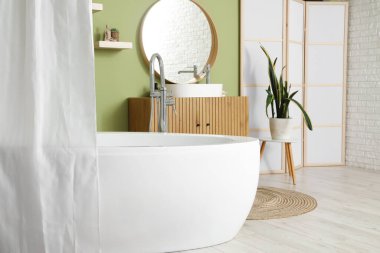 Modern banyonun içinde perde ve ayna olan küvet.