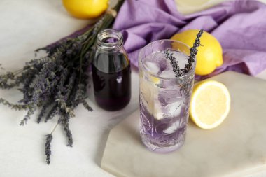 Bir bardak soğuk lavantalı limonata, şurup ve çiçek.
