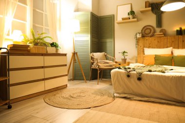 Şık bir yatak odası, rahat bir yatak odası ve geceleri parlayan lambalar.