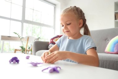 Masada plastikten heykel yapan tatlı küçük kız.