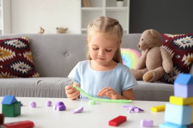 Masada plastikten heykel yapan tatlı küçük kız.