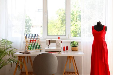 Atölyede dikiş makinesi ve iplik makaralarıyla terzinin işyeri