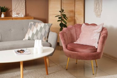 Oturma odasının iç tarafında rahat bir kanepe, koltuk ve sehpa.