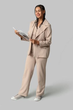 Gri arka planda rasta tutan güzel bir Afro-Amerikalı iş kadını.