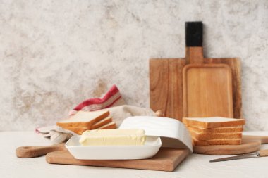 Tahta tahtada tereyağı ve ekmek var.