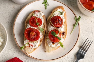 Beyaz arka planda ricotta soslu lezzetli domates bruschetta.