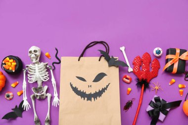 Renkli arkaplanda Cadılar Bayramı için alışveriş torbası, şeker, süsleme ve hediyeli kompozisyon