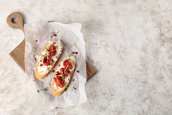 Beyaz arka planda ricotta soslu lezzetli domates bruschetta tahtası.