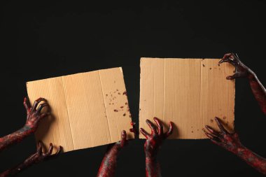 Siyah arka planda boş karton çarşafları olan bir sürü zombi. Cadılar Bayramı