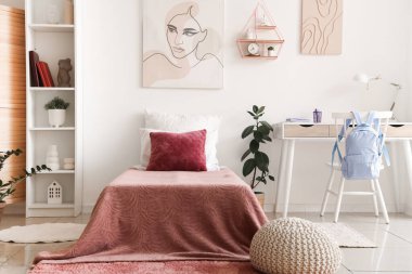 Yatağı, raf ünitesi ve işyeri olan bir gencin odası.