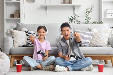 Erkek kardeşi ve kulaklığı evde video oyunu oynuyor.