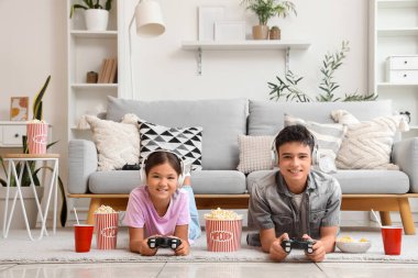 Erkek kardeşi ve kulaklığı evde video oyunu oynuyor.