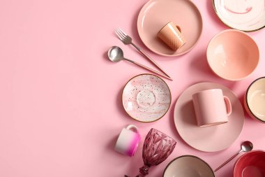 Pembe arka planda bir takım temiz sofra takımı. Üst görünüm