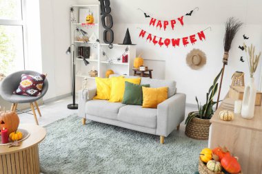 Cadılar Bayramı için dekore edilmiş oturma odasının içi kanepe ve raf ünitesi ile dolu.