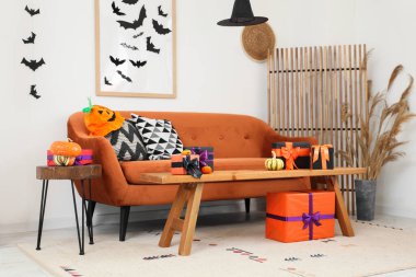 Kahverengi kanepe, Cadılar Bayramı süslemeleri ve hediye kutularıyla dolu bir oturma odası.