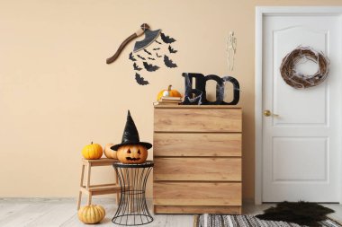 Salonun içi Cadılar Bayramı için kapı, çekmece ve balkabağıyla süslenmiş.