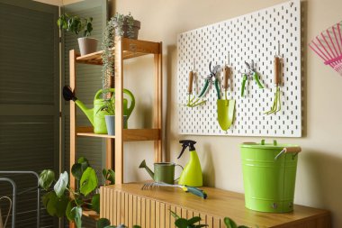 Atölyedeki bej duvarda bahçe aletleri olan Peg tahtası