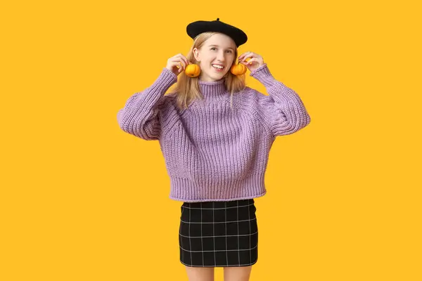 stock image Beautiful young happy woman in beret with Halloween pumpkins on yellow background