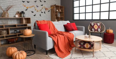 Cadılar Bayramı süslemeleri ve gri kanepeli oturma odasının içi.