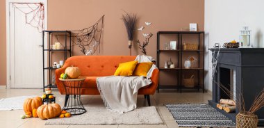 Cadılar Bayramı süslemeleri, şöminesi ve kanepesi olan bir oturma odası.