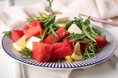 Beyaz ahşap arka planda lezzetli karpuz salatası.