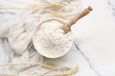 Buğday unu ve kepçe beyaz mermer masa, yakın plan.