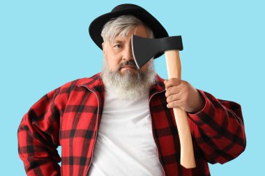 Mavi arka planda baltayla yüzünü kapatan olgun oduncunun portresi