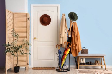 Koridorun içinde kapı, şemsiye ve askılık var.