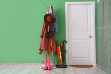 Koridorun içinde kapı, şemsiye ve askılık var.