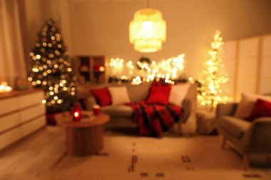 Geceleri tatil için süslenmiş kanepesi ve Noel ağacı olan rahat oturma odasının içi bulanık.