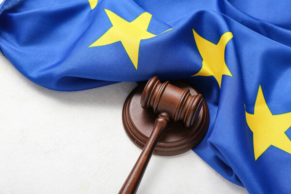 Judge's gavel and flag of European Union on white table