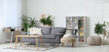 Tropikal bitkiler ve şık koltuklu modern bir oturma odası.