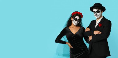 Meksika Ölüler Günü (El Dia de Muertos) için giyinmiş genç çift açık mavi arkaplan ve metin için yer var