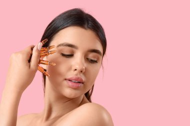 Pembe arka planda ampulleri olan güzel bir genç kadın, yakın plan.