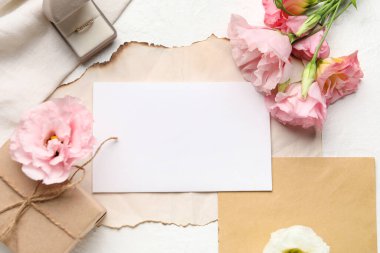 Boş kartlı kompozisyon, alyans ve arka planda östoma çiçekleri, yakın plan