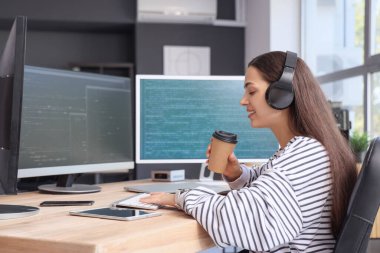 Ofiste çalışan bir fincan kahveyle güzel bir bayan programcı.