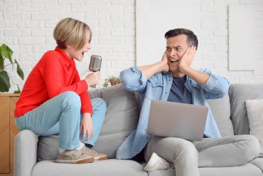 Çalışan genç adam, gürültücü oğlunun evde şarkı söylemesinden dolayı stresli.