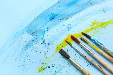 Sanatçı fırçaları mavi arka planda boya ile