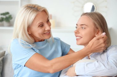 Annesiyle birlikte evdeki oturma odasında mutlu ve güzel bir kadın.