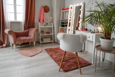 Parlayan aynası ve makyaj masası olan makyaj odasının içi.