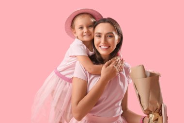 Şirin küçük kızı, güzel annesini pembe arka planda bir buket gülle selamlıyor. Anneler Günün kutlu olsun.