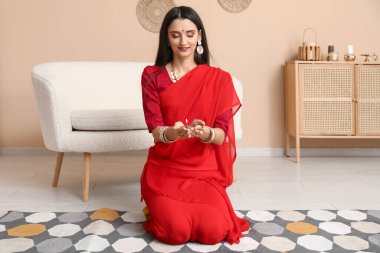 Sari giymiş, evinde diya lambası olan güzel bir Hintli kadın. Divaly kutlaması