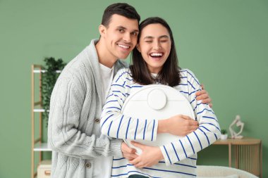 Modern robot elektrikli süpürgesi olan genç çift oturma odasında.