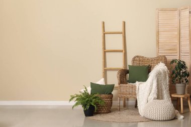 Oturma odasının içinde minderleri ve ekoseli saman koltuklar.